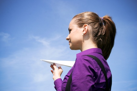 Young businesswoman with paper plane in the handの写真素材