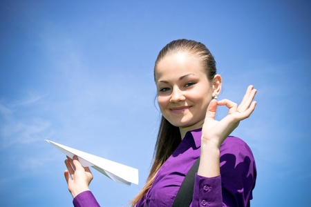 Young caucasian girl with paper plane in the handの写真素材