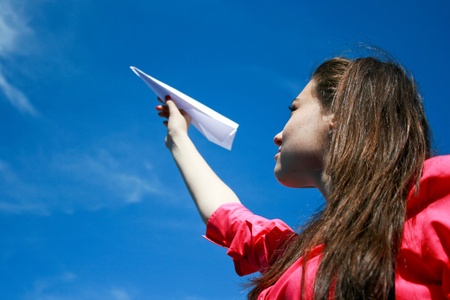 Young caucasian girl with paper plane in the handの写真素材
