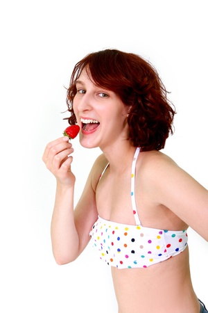 Young woman eating a strawberryの写真素材