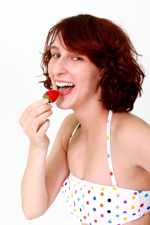 Young woman eating a strawberryの写真素材