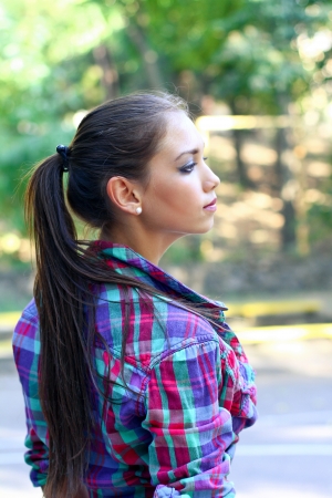 Portrait of serious girl outdoors behind on a background of treesの写真素材