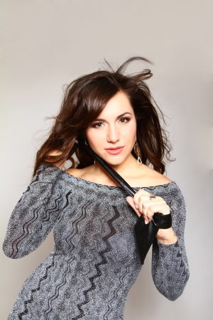 Sexy young woman with a leather belt on a gray background posingの写真素材