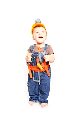 Child in an orange helmet with tools on  white backgroundの写真素材
