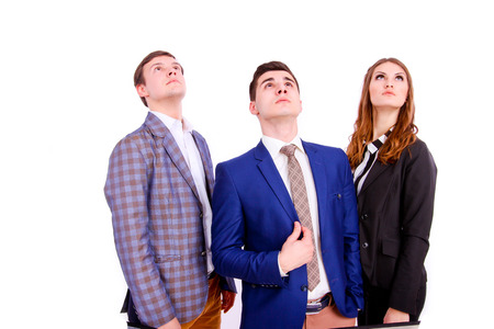 Three young business people looking up isolatedの写真素材