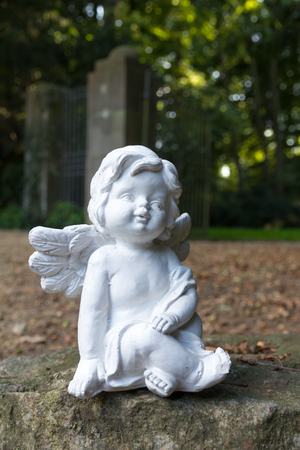 angel statue sitting on a stoneの写真素材