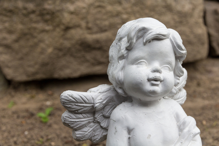 angel figure in front of brick wallの写真素材