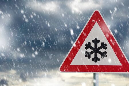 Warning road sign and heavy snowfallの写真素材