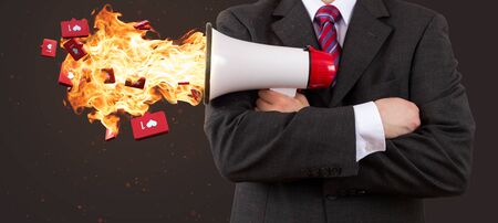 Business man holding megaphone on fire with red hot likesの写真素材