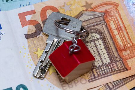 Key with house shaped key chain on euro banknotesの写真素材