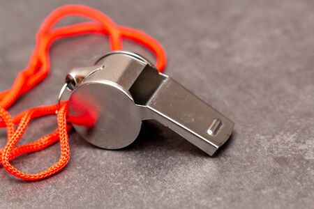 Metal whistle on slate, closeup photo