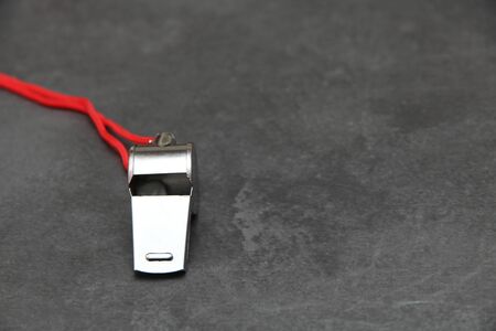 Metal whistle on slate, closeup photo