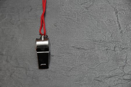 Metal whistle on slate, closeup photoの写真素材
