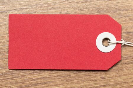Red tag on wooden backgroundの写真素材