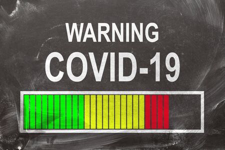 Warning Covid-19 written on chalkboardの写真素材
