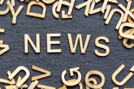 Wooden letters NEWS on slate backgroundの写真素材