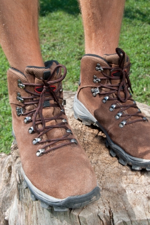 A man stands on a tree stump in a trekking brown shoes.の写真素材