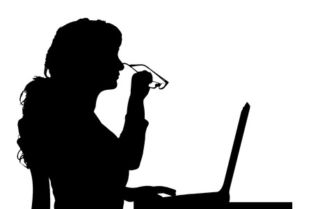 Vector silhouette of a woman sitting at a computer on a white background.のイラスト素材