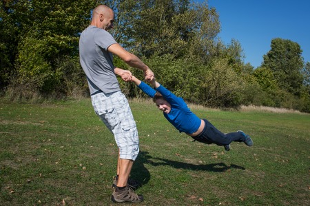 A father with son are playing in the park at sunny day.の写真素材