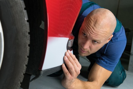 Man checks the softness of the paint on the car.の写真素材