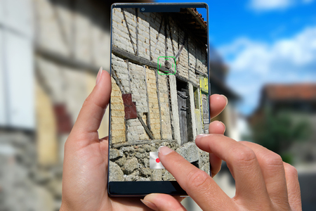 Woman with mobile phone photos old house.の写真素材