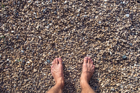 The manÂ´s feet on the small stones.の写真素材