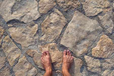 The man's feet on the stone floor.の写真素材