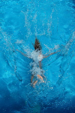 Small girl jump in the swimming pool.の写真素材