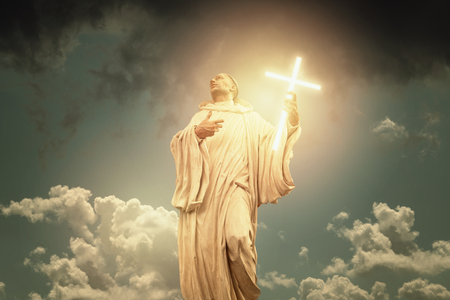 God phantasy holy statue with crucifix and dramatic sky.の写真素材