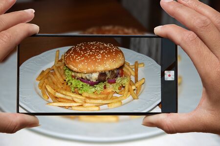 Tasty grilled home made burger with beef, tomato, cheese, cucumber and lettuce. With copy spaceの写真素材