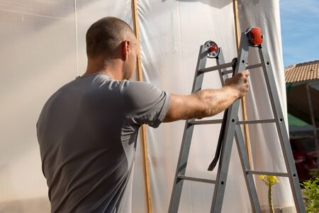 Construction worker climbs a ladder at work.