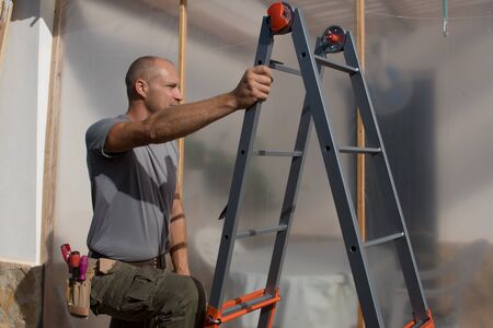 Construction worker climbs a ladder at work.の写真素材