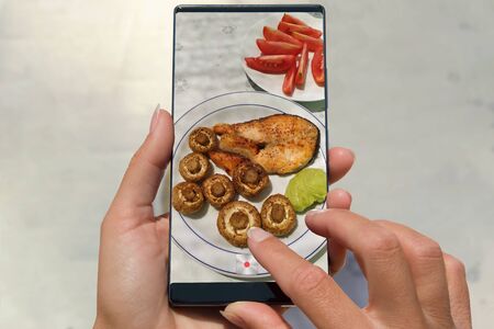 Woman photographing on cell phone homemade healthy food.の写真素材