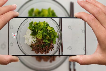 Woman photographing on cell phone homemade healthy food.の写真素材
