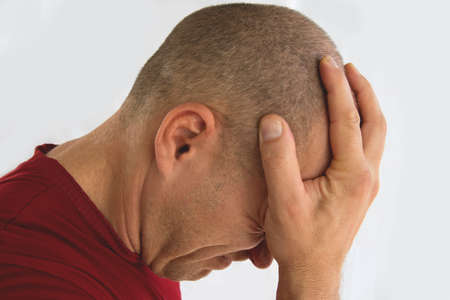 Man isolated on white background suffering from severe headache.