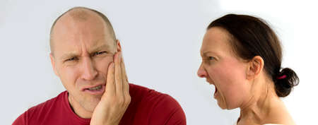 Woman shouts at man who protects himself with his hands blocking the attack.の写真素材