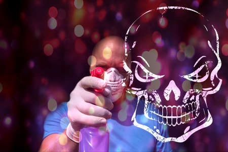 Concept man sprays disinfectant with picture of a skull in the foreground.の写真素材
