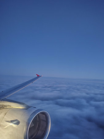 View of the wing of a passenger plane flying above the clouds.