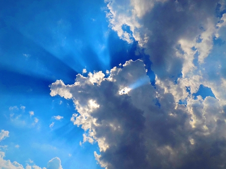Sun behind the cumulus clouds