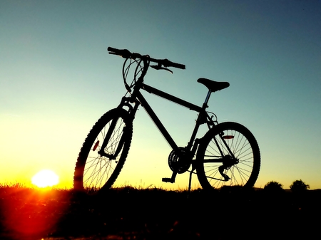 Mountain bike on hill during sunsetの写真素材