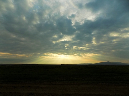 Shining sun through clouds during sunsetの写真素材