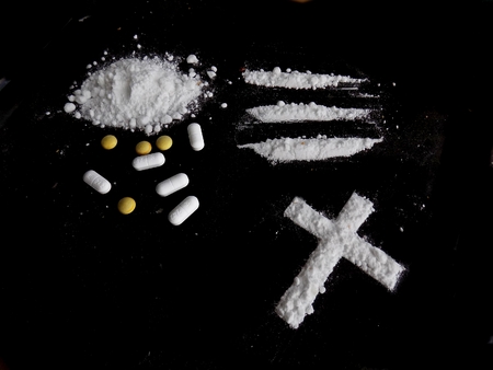 Cocaine drug powder, lines and cross and pills on black backgroundの写真素材