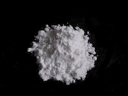 Cocaine drug powder pile on black background