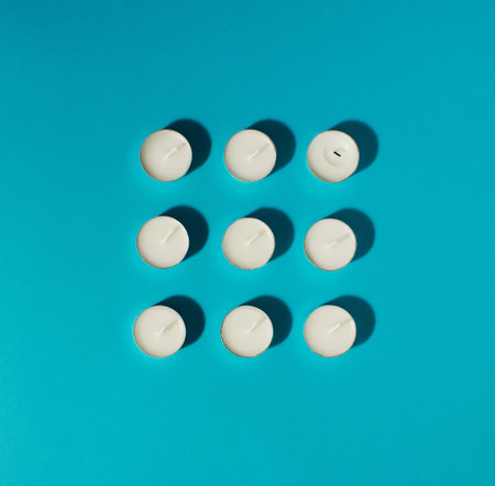 White candles on the bright blue background. Minimal concept.の写真素材