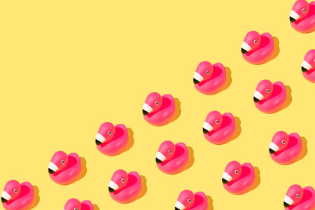 Summer pattern with rubber pink flamingos on yellow background. Copy space.の写真素材