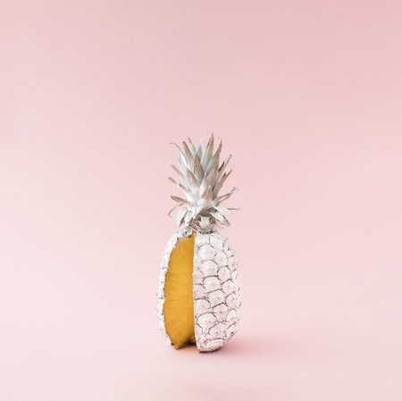 Fresh pineapple colored in white with one cut slice. Minimal summer food concept idea.の写真素材