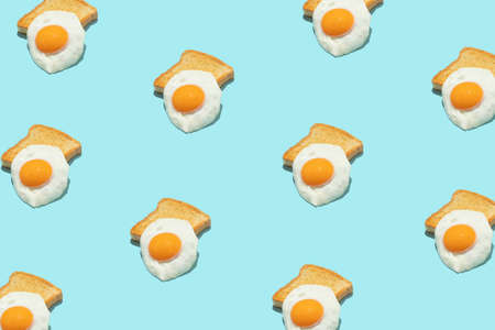 Seamless creative food pattern. Fried eggs on blue background.の写真素材