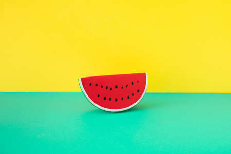Rubber watermelon slice on turquoise and yellow background. Summer minimal concept.の写真素材