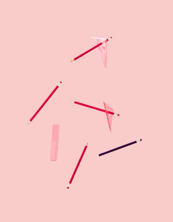 School accessories. Pencils and triangle rulers floating against pink background.の写真素材