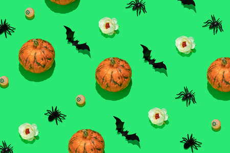 Halloween pattern with orange pumpkins, black bats and spiders, eyeballs and white flowers on green...